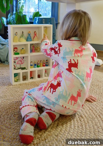 Clara happily interacting with her new figurine cubby, organizing and playing with her toys.