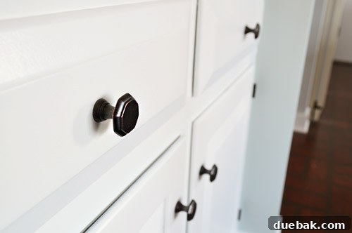 Effortlessly Transform Your Kitchen with White Upper Cabinets 16 New oil-rubbed bronze octagon knobs on white kitchen cabinets, showcasing contrast.