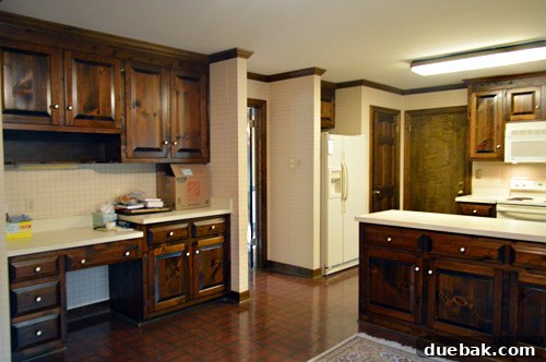 Effortlessly Transform Your Kitchen with White Upper Cabinets 17 Overall view of the updated kitchen with white upper cabinets and new hardware.