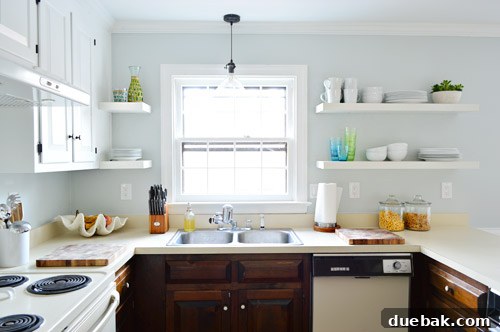 Effortlessly Transform Your Kitchen with White Upper Cabinets 20 After shot of the kitchen sink area with newly painted white cabinets.