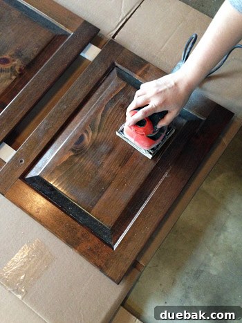 Effortlessly Transform Your Kitchen with White Upper Cabinets 6 Sanding kitchen cabinet frames by hand for optimal paint adhesion.