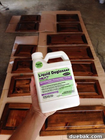 Effortlessly Transform Your Kitchen with White Upper Cabinets 7 Applying liquid deglosser to cabinet surfaces after sanding to prepare for primer.