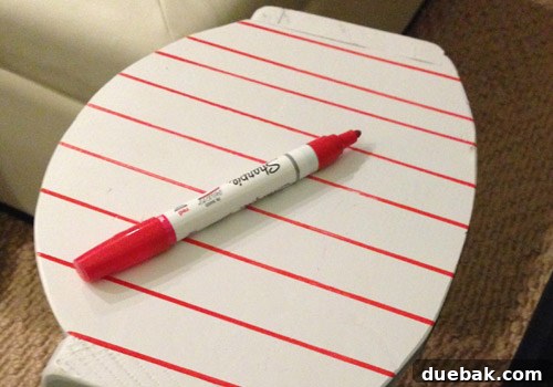 Detail shot of the initial vertical lines being drawn on the wooden cradle with a red Sharpie paint pen and a ruler.