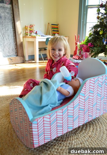 Close-up of Clara's joyful reaction as she points at the geometric shapes on the painted cradle.