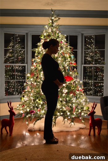 Capturing the Last Christmas Tree Photo with Our Little One Family posing in front of a brightly lit Christmas tree, capturing a cherished holiday moment.