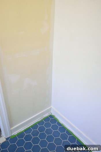 Our Bathroom's Wallpaper Detox 14 Bathroom walls, half-primed, showing the stark contrast between the original wall color and the bright primer.