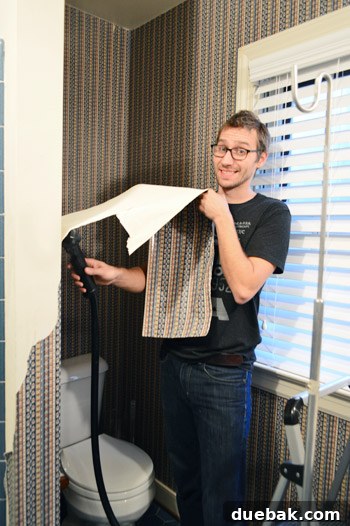 Our Bathroom's Wallpaper Detox 5 Person looking tired and disheveled during wallpaper removal, indicating frustration.