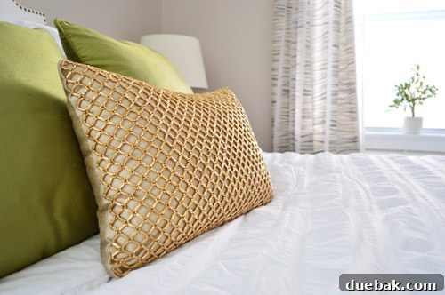 Detailed shot of the luxurious textured bedding and decorative pillows