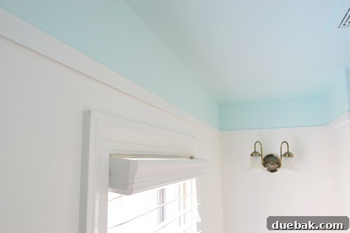 Bathroom Ceiling Transformation with Paint and Trimwork 10 Caulking the edges of the installed lattice trim for a seamless finish in the renovated bathroom.