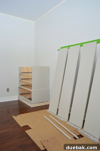 Craft Your Own Library Haven 7 Various pre-cut and painted wood pieces, ready for assembly into a homemade DIY bookshelf, demonstrating preparation before installation.