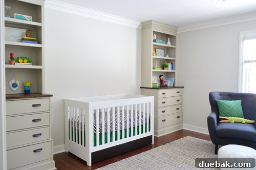 Nursery built-in shelves displaying books, toys, and a handmade paper mache narwhal bust