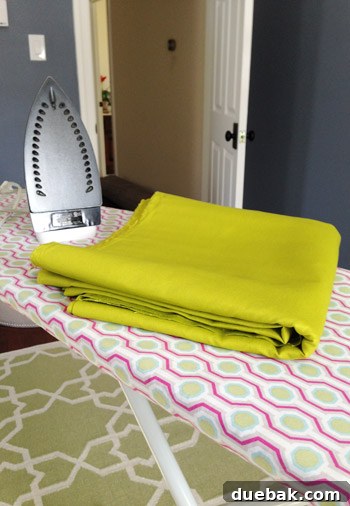 Bolt of apple green cotton fabric from JoAnn's, ready for custom curtain creation.