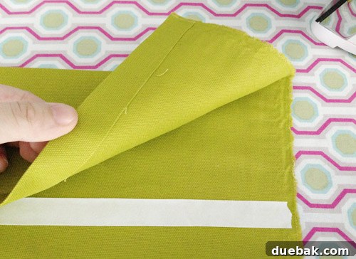Applying hem tape to secure the folded 4.5-inch hem, ensuring a strong bond.