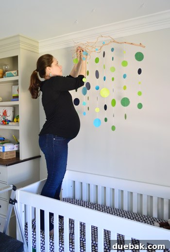 Craft Your Own Adorable Nursery Mobile 19 Adult man lying in a baby crib, humorously testing its comfort and size