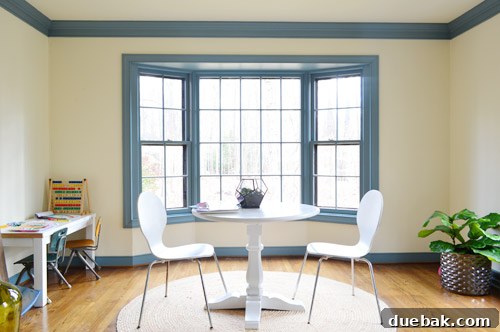 A bright home office room showcasing a beautiful bay window as a focal point.