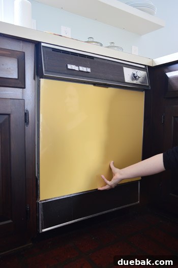 Give Your Dishwasher a Color Makeover 7 Mustard yellow dishwasher panel held up