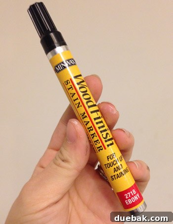 Using a stain marker to blend wood putty on the table