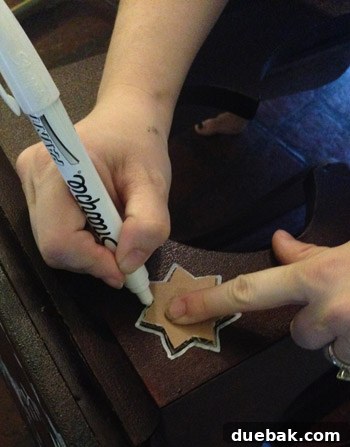 Tracing and filling in a star design on the table with a paint pen