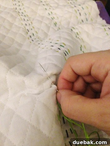 Detailed shot of hand-stitching following diamond patterns on fabric
