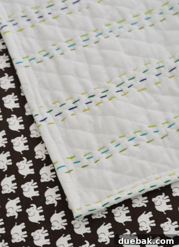 Completed hand-stitched quilt showing the varied stripe pattern