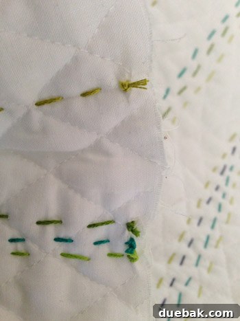 Close-up of the back of the quilt showing neatly tied knots along the edge