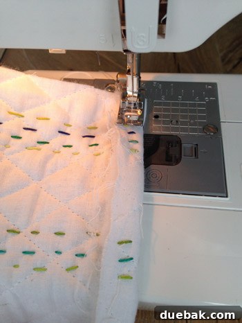 Sewing machine hemming the edge of the baby quilt