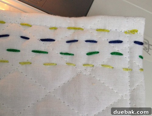 Front view of the finished hand-stitched baby quilt with clean edges