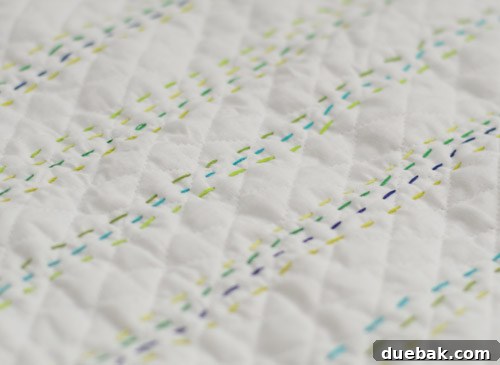 Close-up of the finished baby quilt, showcasing intricate stitching