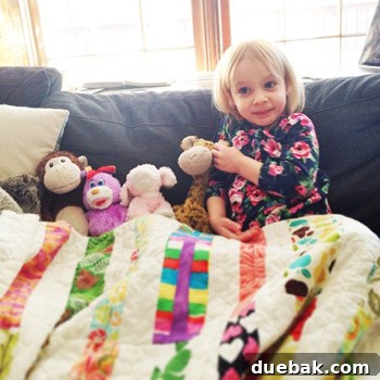 Child snuggled on a sofa with her cherished handmade quilt