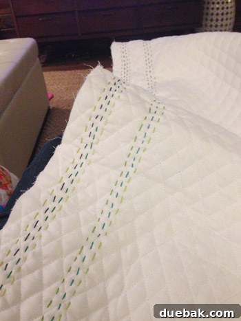 Close-up of hand-stitching in progress on quilt fabric