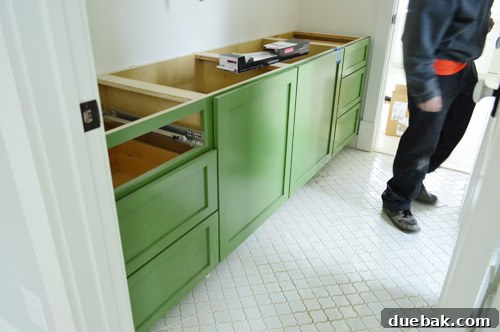 Kids' bathroom vanity in green with lantern tiles.