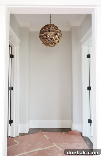 A small nook with a grey wall and pendant light, called 'The Atrium'.