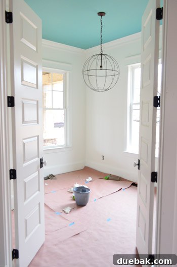 Empty room with covered hardwood floors and new lighting.