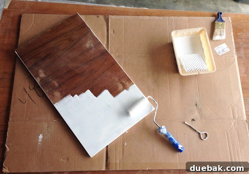Applying Kilz Premium primer to the desk using a small foam roller.