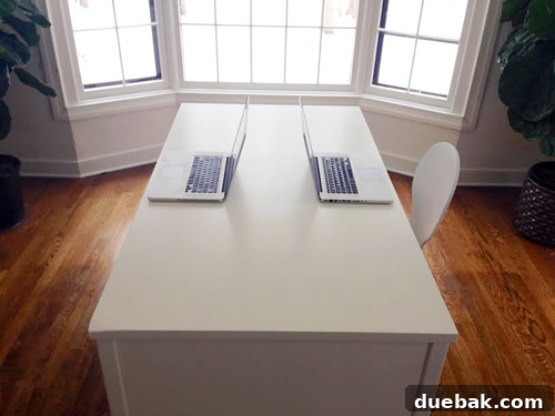 The refurbished desk with two laptops placed on it to demonstrate space for two users.