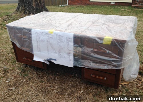 Loading the free Craigslist desk into the car, demonstrating its impressive size.