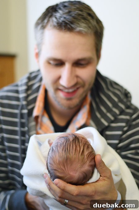 He Makes His Entrance 4 A charming close-up photograph of baby Teddy's adorable face, showcasing his sweet expression and abundant dark hair, a truly heartwarming detail.