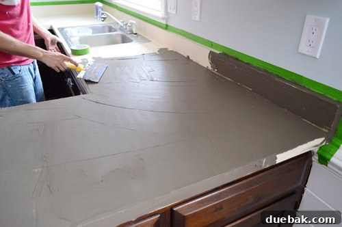 Using a wide blade to spread Ardex on kitchen counters