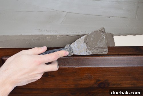 Applying Ardex to the side edge of a countertop with a putty knife