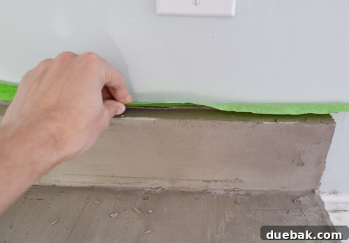 Peeling off painter's tape from the wall after Ardex application