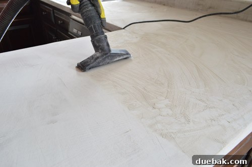 Vacuuming dust from concrete countertops during sanding