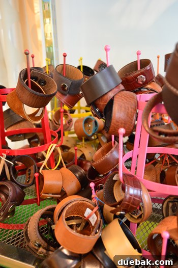 Display racks showcasing an array of unique leather jewelry cuffs, handmade and ready for sale in the creative studio.