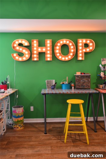 Large downstairs workshop featuring vintage-style light-up letters spelling out a name, creating an inspiring and branded workspace.