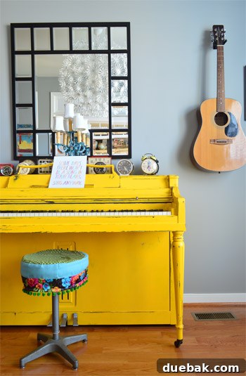 Bright yellow painted piano takes center stage in the music room, with a guitar displayed on the wall, creating a vibrant and artistic space.