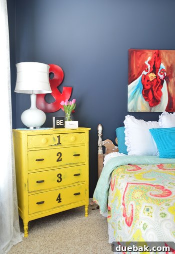 DIY yellow dresser with unique numbers adorning each drawer, showcasing a creative and personalized touch in the bedroom.