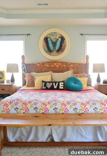 Large bed decorated with funky pillows and delicate string lights draped across the headboard, creating a cozy and inviting ambiance.