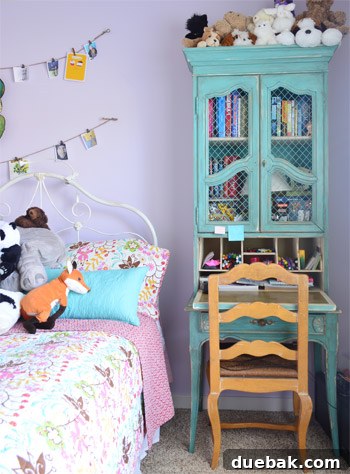 Vintage desk in a child's room with charming hanging pictures, creating a personalized and artistic space for creativity.