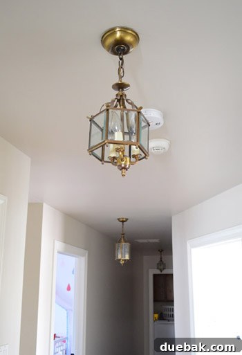 Dated hallway with small, mismatched light fixtures
