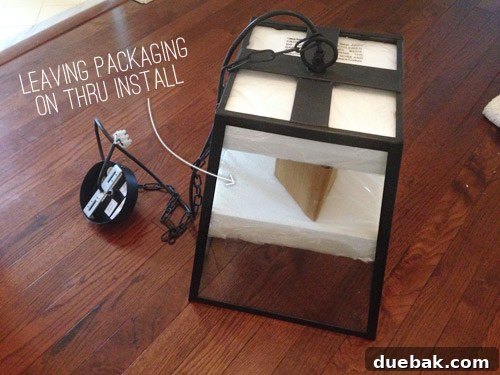 Installer working on a light fixture with protective packaging still on