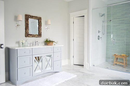 Custom gray vanities with driftwood mirrors and elegant sconces